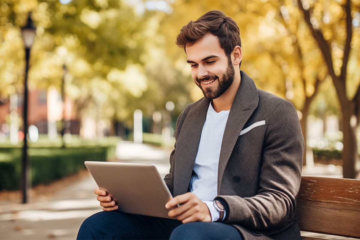 Ein Mitarbeitender arbeitet mit der Cloud-Büro Lösung von Smart Data Center mit seinem Endgerät flexibel von einer Bank im Park aus. © Adobe Stock, Graphic Master