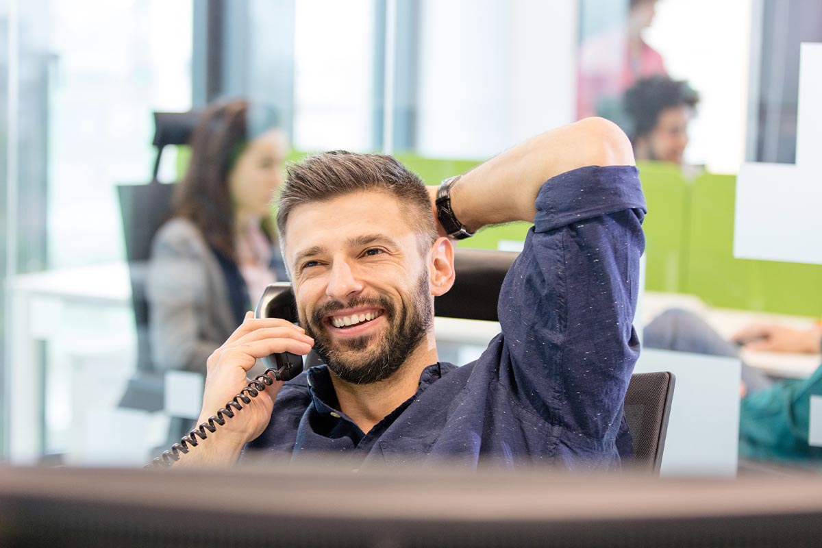 Ein Mann lächelt am Telefon, denn der virtuellen Server von Smart Data Center bietet eine sichere Cloud-Umgebung © Shutterstock, sirtravelalot